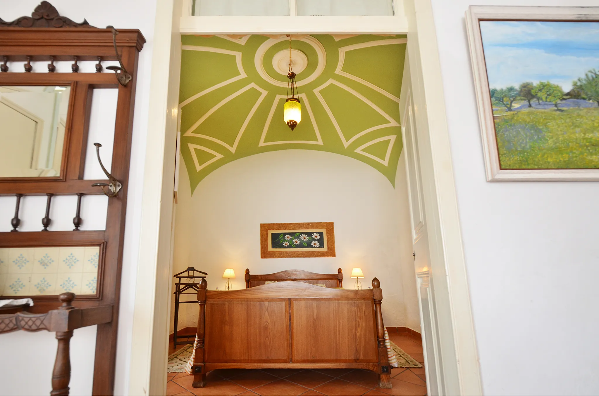 Quarto com teto abobadado pintado de verde, visto da porta